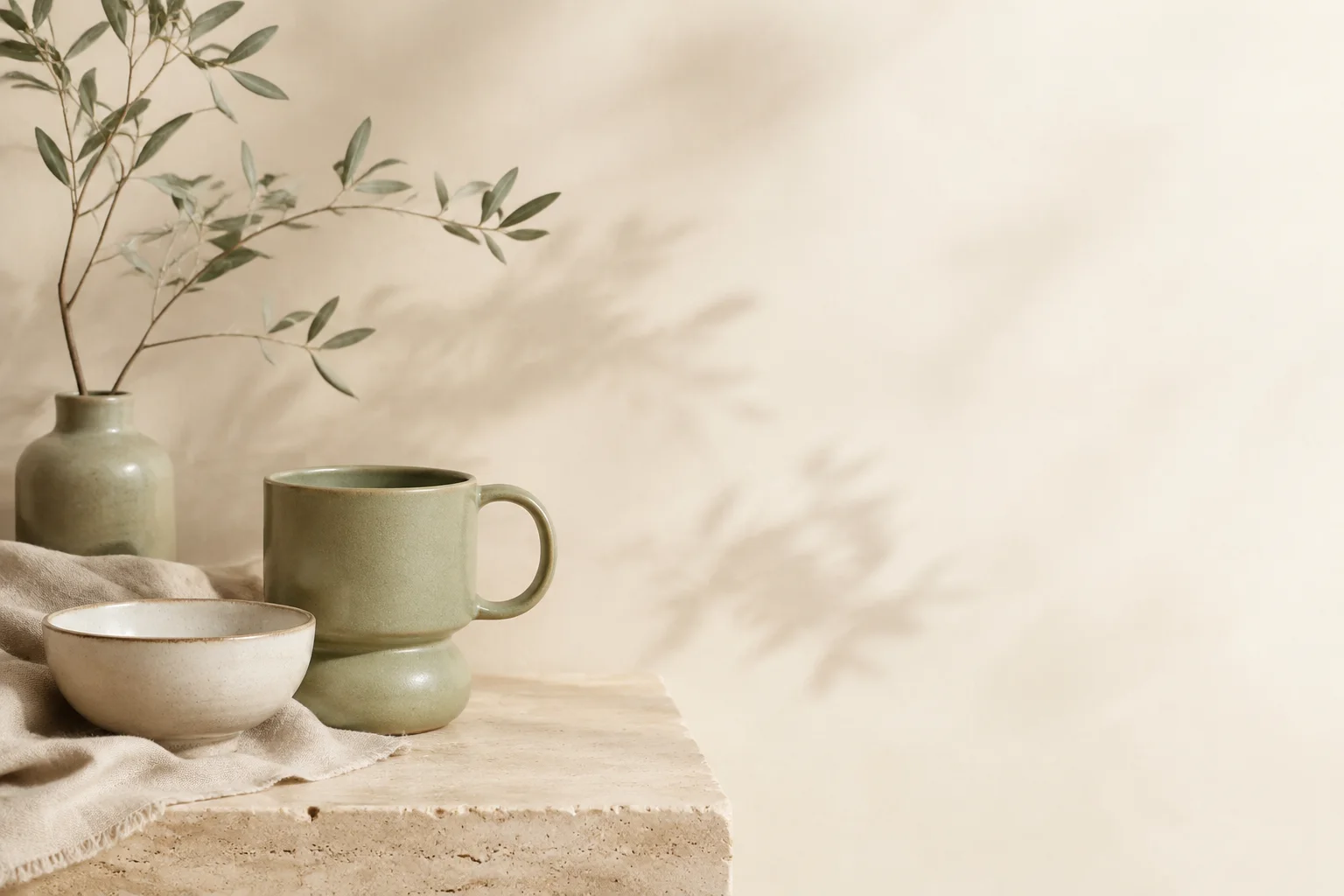 Sage ceramic mug and ivory bowl on natural linen, an illustrative homewares storefront